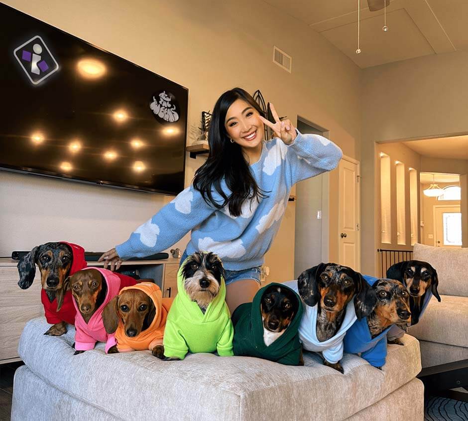 http://influencer%20posing%20with%20eight%20weenie%20dogs%20in%20colorful%20sweaters