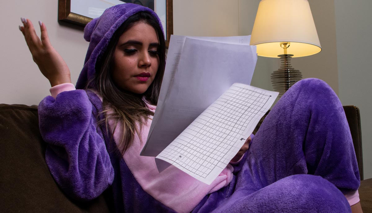 young woman in purple onsie reading paperwork